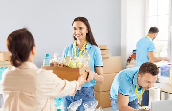 Fiatal önkéntes ingyenes élelmiszer-adománydobozt ad a rászorulóknak egy jótékonysági alapítványban.