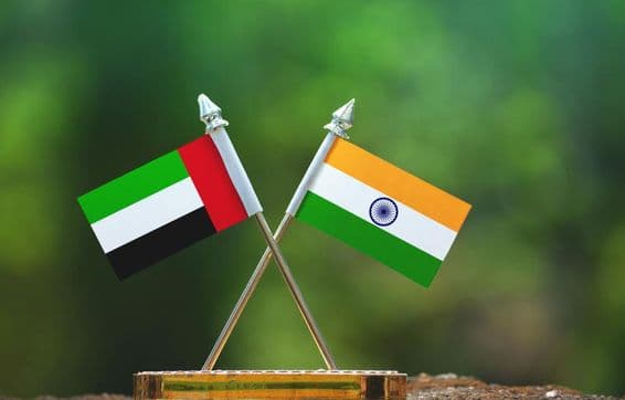 India és az Egyesült Arab Emírségek kis zászló elmosódott zöld háttérrel.