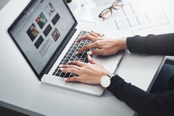 Távmunkában dolgozó nő otthonról használja a laptopját.