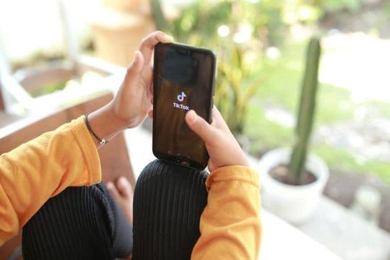 Egy gyerek tik-tok média tartalmat néz meg mobiltelefonon.