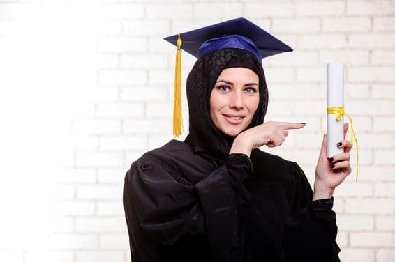 Boldog végzős muzulmán diák oklevéllel pózol bent.