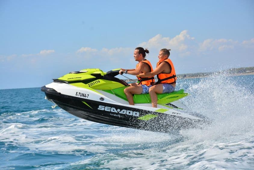 Fiatalok jetskiznek a tengeren.