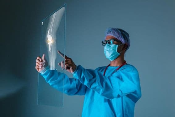 Orvos kezében a páciens csont röntgen képe műtét előtt.