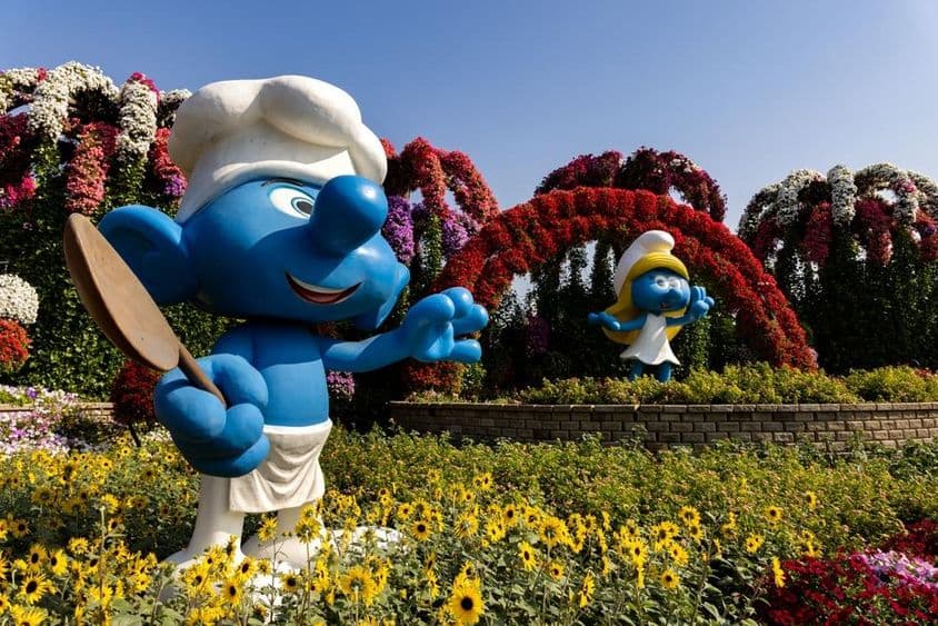 Kék Törpök életnagyságú figurái színes virágokkal a dubai Miracle Gardenben.