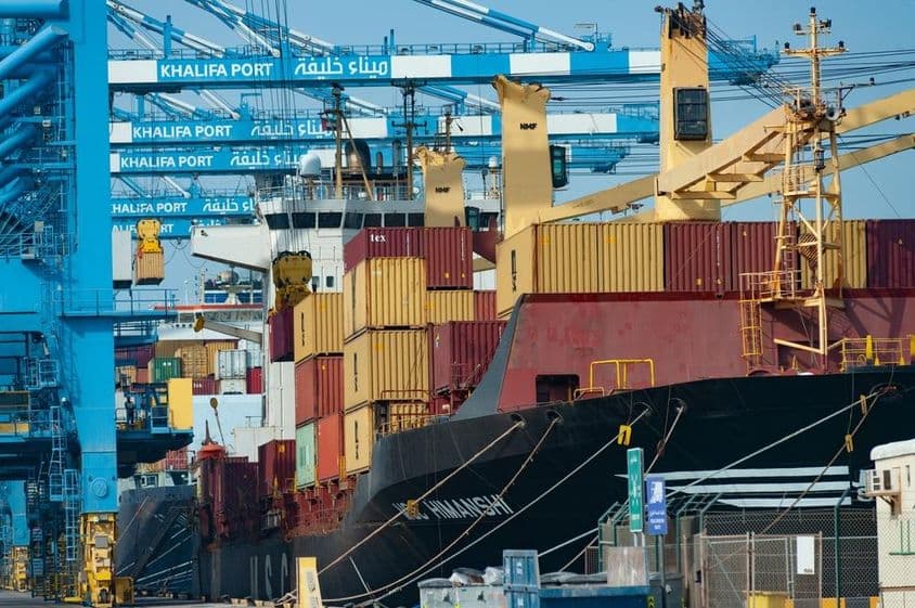 Konténerek kirakodása egy konténerhajóról Khalifa Portban, Abu Dhabiban.