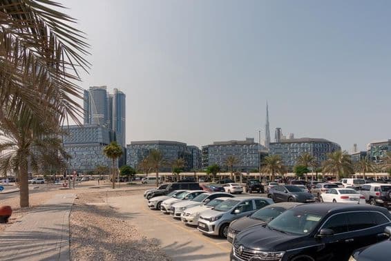 Kilátás a dubai tervezési negyed modern irodaházaira a parkoló területérő.