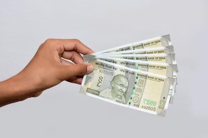 Egy férfi kezében indiai új valuta 500 rúpiás.