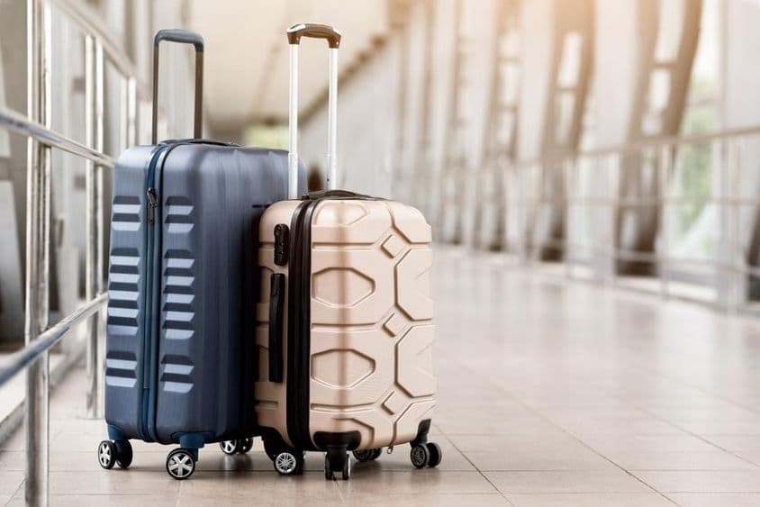 Két műanyag bőrönd az üres repülőtéri folyosón.