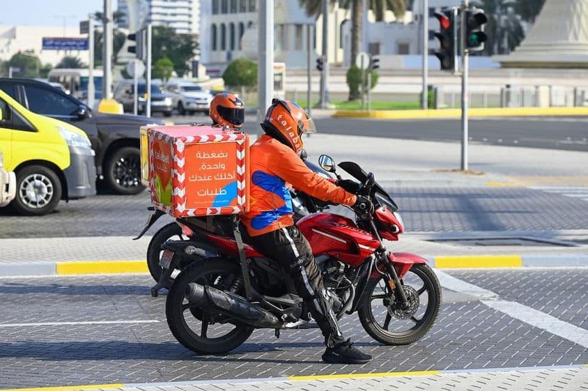 A Talabat online ételrendelési cég futárai Abu Dhabi utcáján.