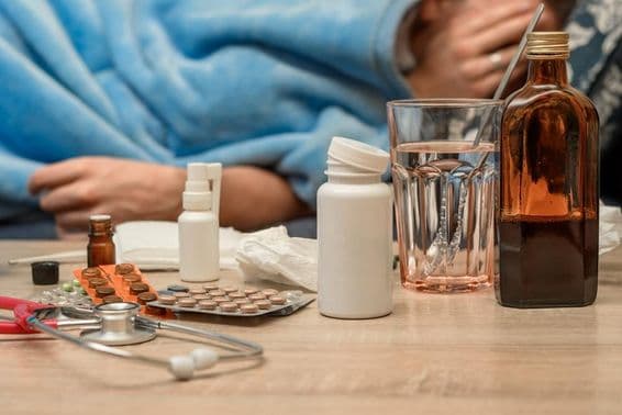 Egy megfázott férfi lázzal fekszik az ágyban.