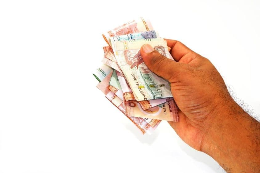 Dirham bankjegyek kézben fogva.