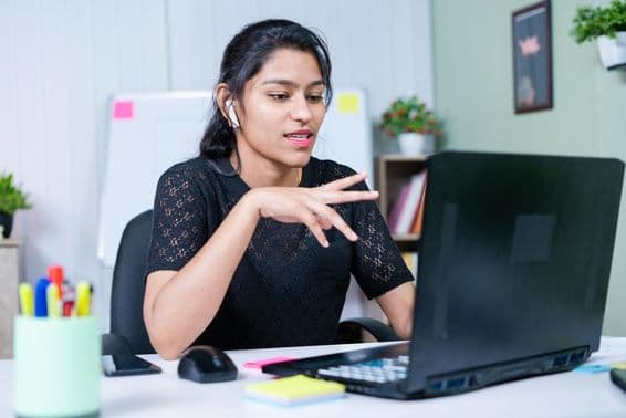 Fiatal indiai üzletasszony meggyőzi az ügyfelet a projektről videohíváson keresztül.