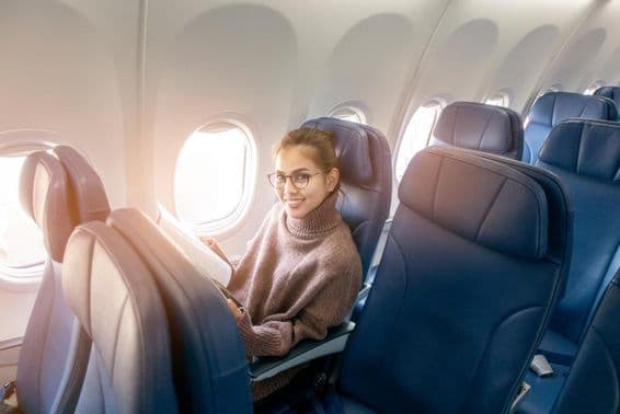 Ázsiai nő magazint olvas a repülőgépen.