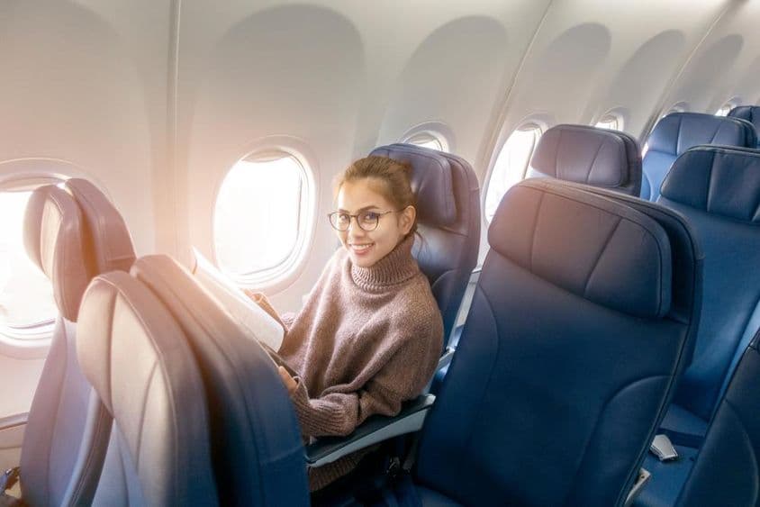 Ázsiai nő magazint olvas a repülőgépen.