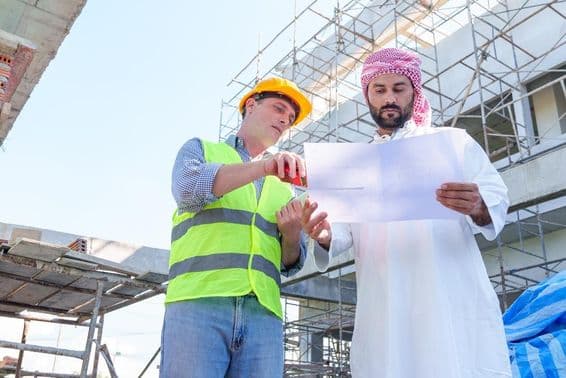 Arab üzletember építőmérnök tervrajzát nézi.