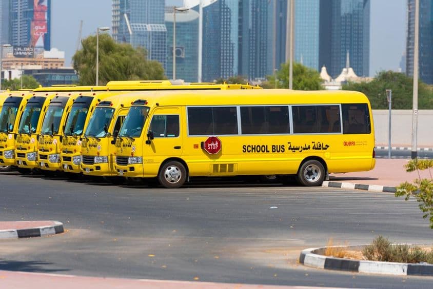 Dubai sárga iskolabuszok sorakoznak fel és parkolnak kint.