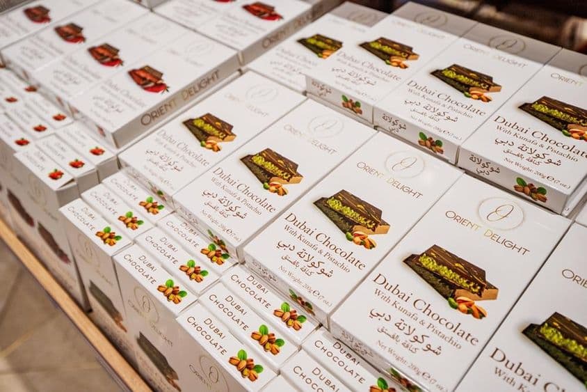 Dubai csokoládé bárok kunafa és pisztácia töltéssel rakva egy bolti polcon.