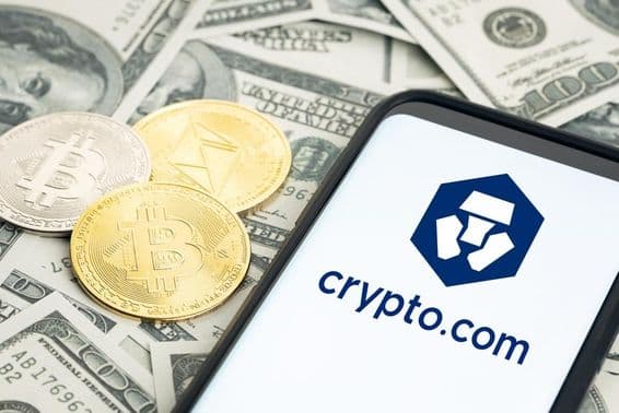 Crypto.com logó, dollárbankjegyek, bitcoin és ethereum érmék láthatók.