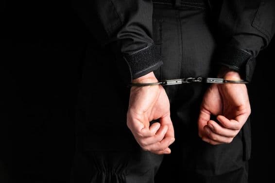 Bűnöző kezei bilincsbe zárva.