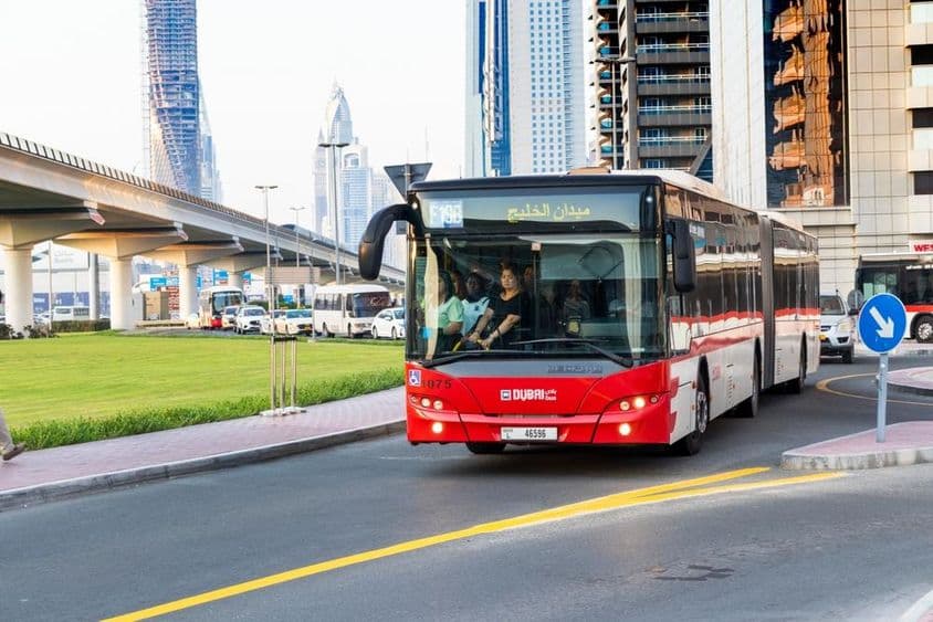 Dubai busz és modern felhőkarcoló a Sheikh Zayed út mentén.