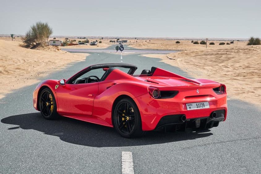 piros Ferrari 488 egy elhagyatott dubai sivatagi úton.