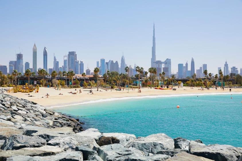 A La Mer strandja, a háttérben Dubai, Egyesült Arab Emírségek látképével.