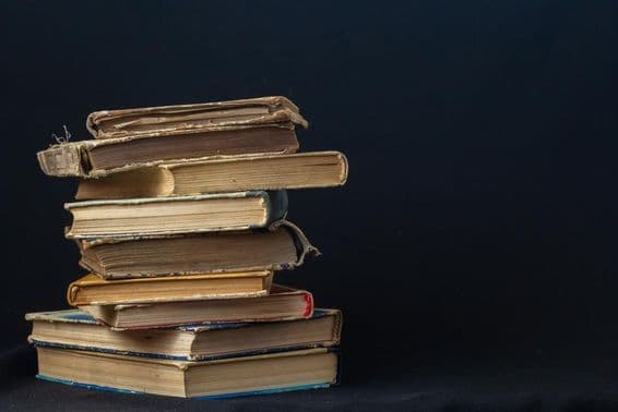 Egy halom keményfedeles régi könyv.