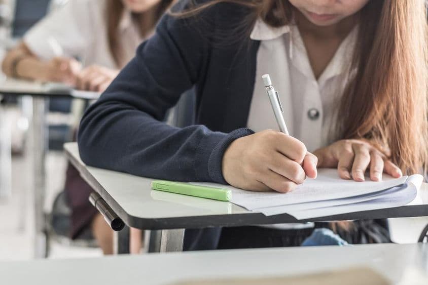 Az iskolai tanuló osztályterembe vizsgát ír.