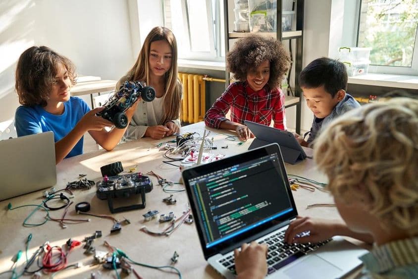 Iskolás gyerekek robotautókat építenek számítógépek, programozás segítségével.