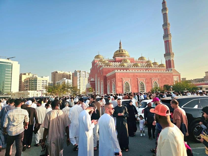 Nagy tömeg gyűlt össze egy kupolákkal és magas minarettel rendelkező nagymecset előtt.