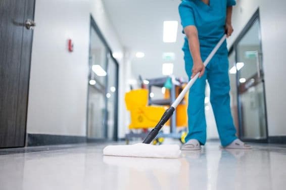 takarító felmosóval takarít a csarnok padlóján.