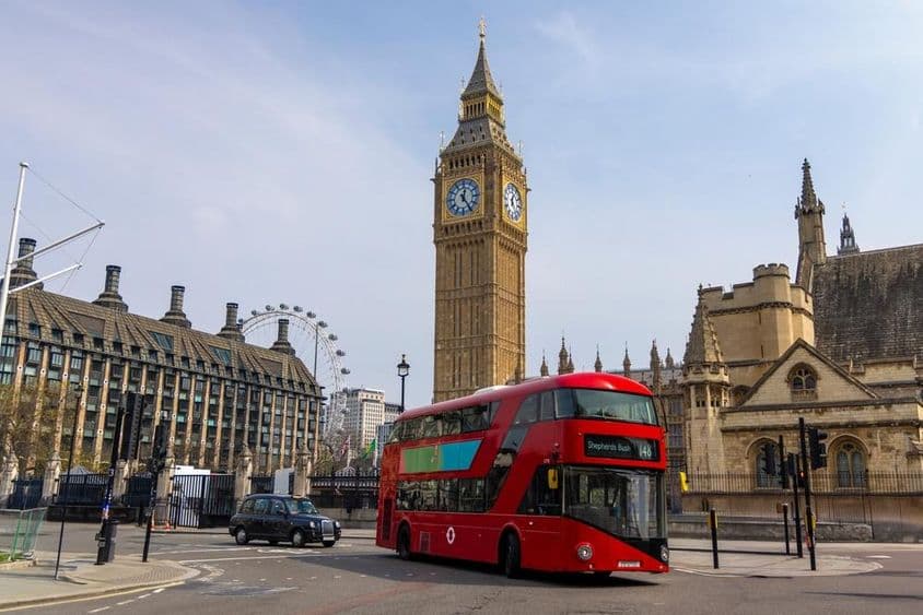 Piros double decker busz elhalad a történelmi Big Ben előtt Londonban.