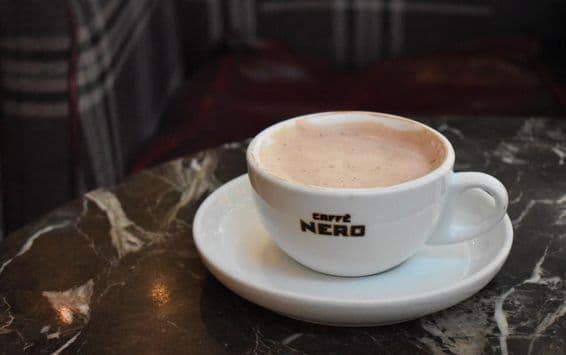 Egy csésze forró csokoládé egy márványasztalon a Caffe Nero-ban.