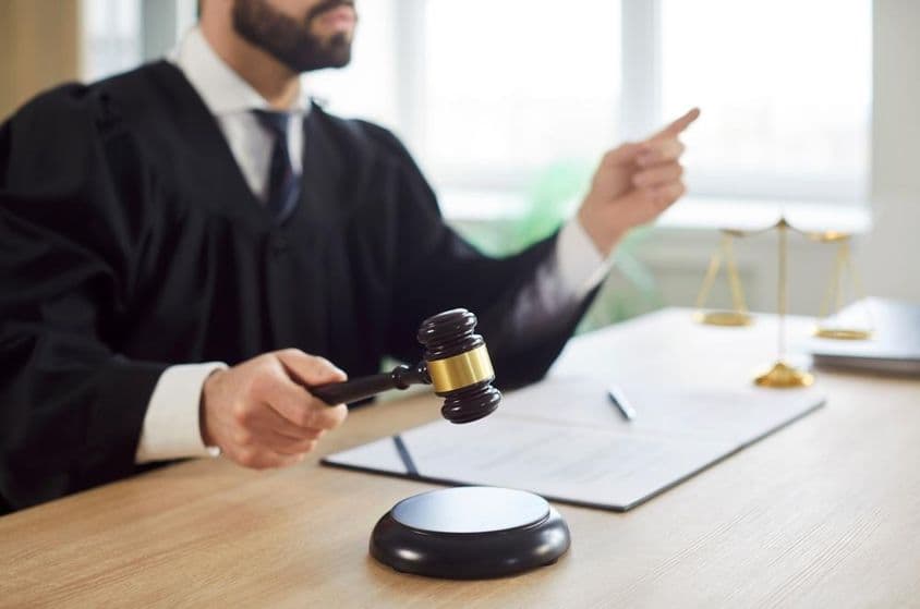 A bíró kopogtat, és a bíróság ítéletet hoz a tárgyalóteremben.