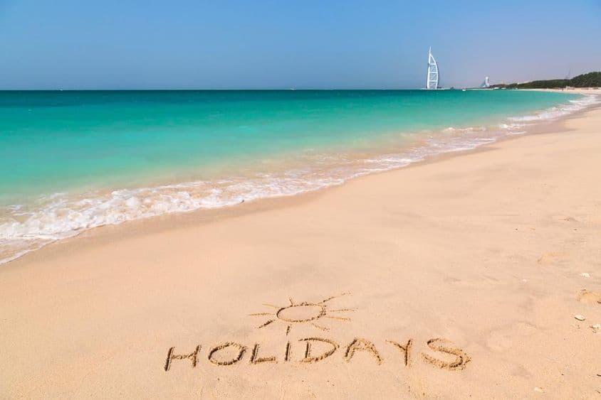 Ünnepek felirat a türkizkék vízzel teli strandon.