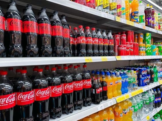 Cola üvegek sorban a polcon egy szupermarket polcán.