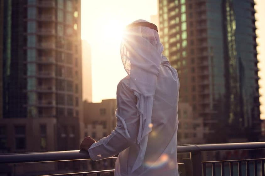 Arab férfi nézi a napnyugtát Dubaiban.