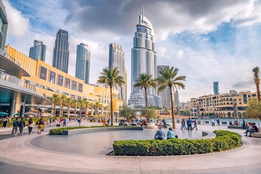 Turisták tömege sétál a Dubai Mall bejárata közelében lévő téren.
