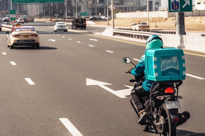 Dubai, férfi motoron online ételkiszállításhoz.