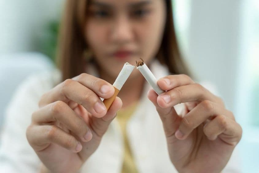 Nincs dohányzás, egy nő ketté tőri a cigarettát.