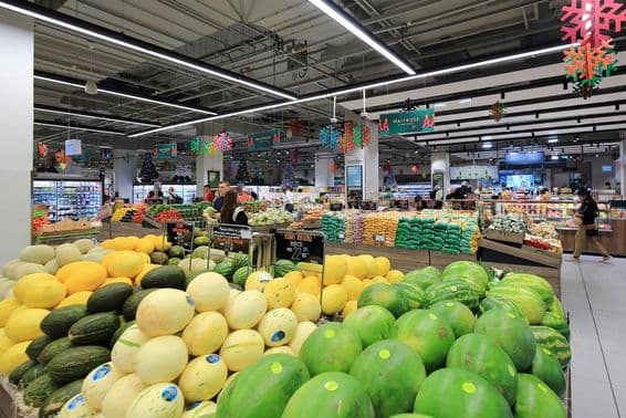 Halmozott zöld és sárga dinnyék eladók a fogyasztóknak a Dubai Mall szupermarketjében.