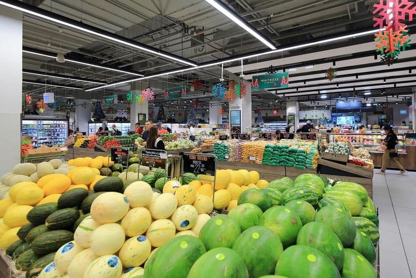 Halmozott zöld és sárga dinnyék eladók a fogyasztóknak a Dubai Mall szupermarketjében.