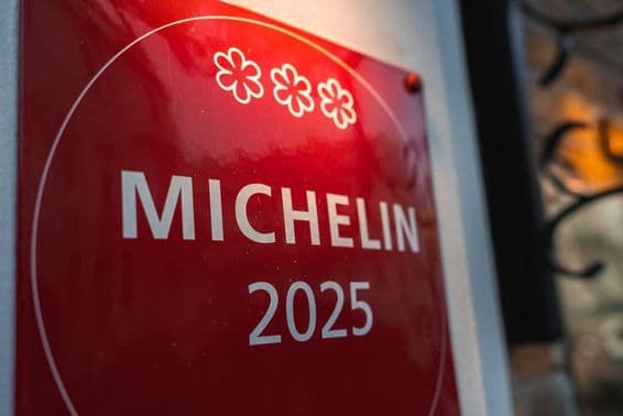 Egy piros, háromcsillagos Michelin 2025-ös emléktábla egy világos színű falon.