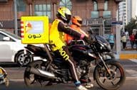 Motoros futár szállítás közben, Dubai utcán.