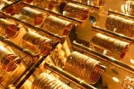 Arany karkötők egy ékszerboltban a dubai Golden Souk piacon.