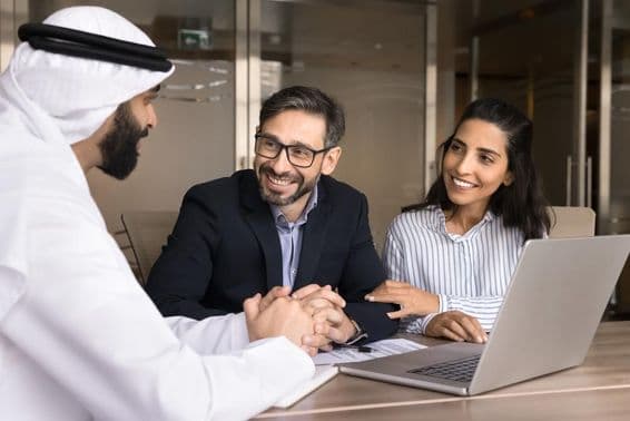 Boldog latin pár találkozik egy arab ingatlaneladóval.