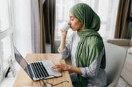 Arab üzletasszony laptopon ellenőrzi az e-mail értesítéseket.