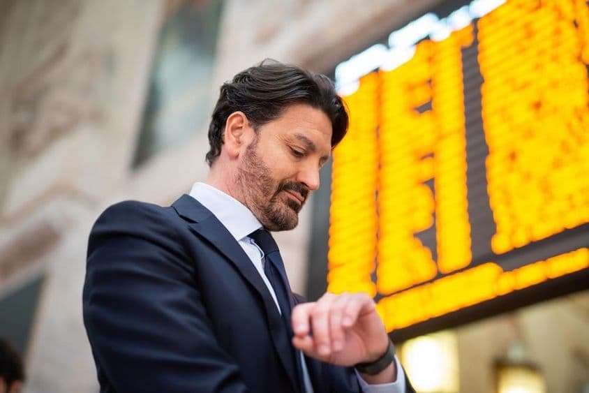 Egy ingázó ellenőrzi az időt a menetrend előtt.