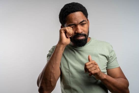 Egy ember dörzsöli a szemét a kellemetlen, irritált és fáradt.