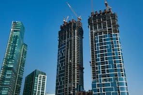 Modern felhőkarcoló apartmankomplexum építés alatt a tengerparton.